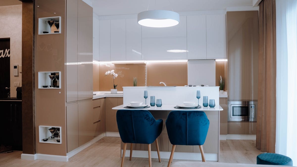 A stylish modern kitchen interior featuring sleek cabinetry and elegant dining setup.